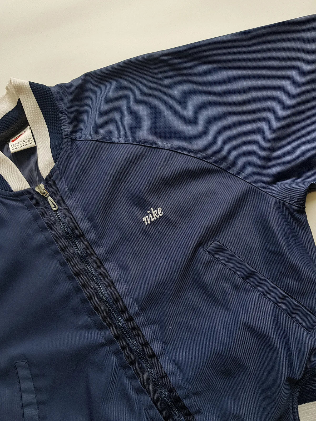 1990s Vintage Authentic Nike Workwear Vibes -  Bomber Style Track Jacket - Navy & Vintage White - Silver Hardware & Big Chunky Metal Zip - Embroidered Nike on the Chest - Elasticated Paneling on Neck Waist & Sleeves - Unworn Condition - Unisex Fit